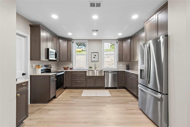241 S Starr Ave, Avalon, PA 15202 - kitchen featuring appliances with stainless steel finishes, dark brown cabinets, light wood-type flooring, light countertops, and recessed lighting