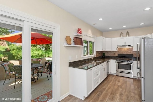 9810 Three Degree Rd, Mccandless, PA 15101 - kitchen with stainless steel appliances, under cabinet range hood, wood finished floors, white cabinetry, and decorative backsplash