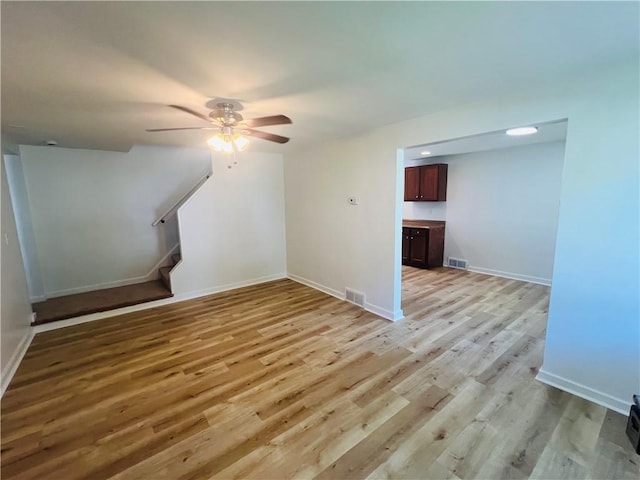 543 Burton Dr, Penn Hills, PA 15235 - unfurnished living room featuring light wood finished floors, a ceiling fan, and stairs