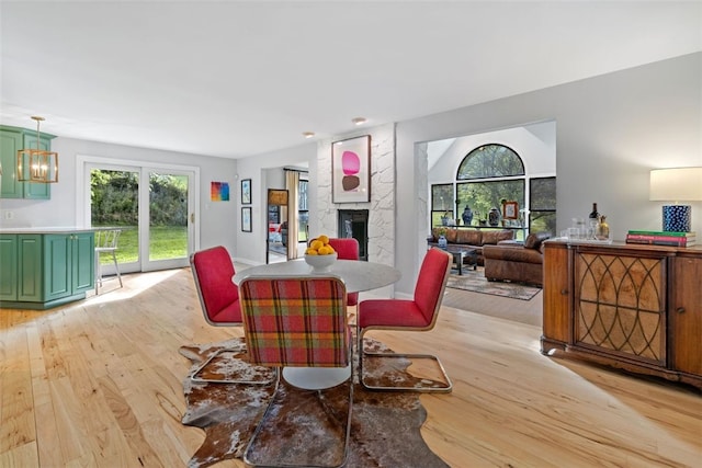 32 Canter Dr, Sewickley Hills Boro, PA 15143 - dining space with light wood-style flooring, plenty of natural light, a fireplace, and a chandelier