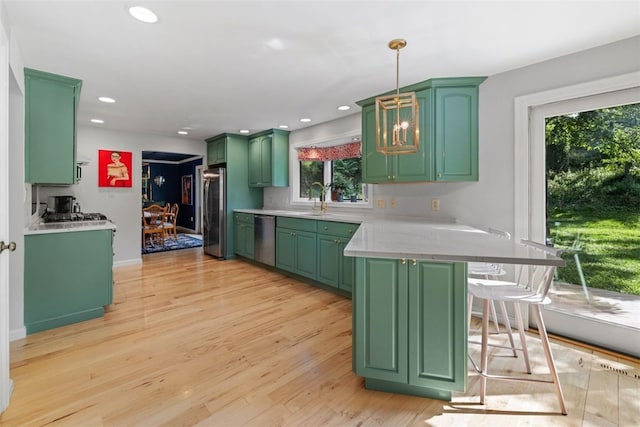32 Canter Dr, Sewickley Hills Boro, PA 15143 - kitchen featuring stainless steel appliances, green cabinets, a peninsula, light countertops, and a breakfast bar