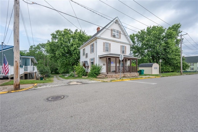701 E 1st Ave, Derry Boro, PA 15627 - view of front of house with a porch, a storage unit, and a chimney