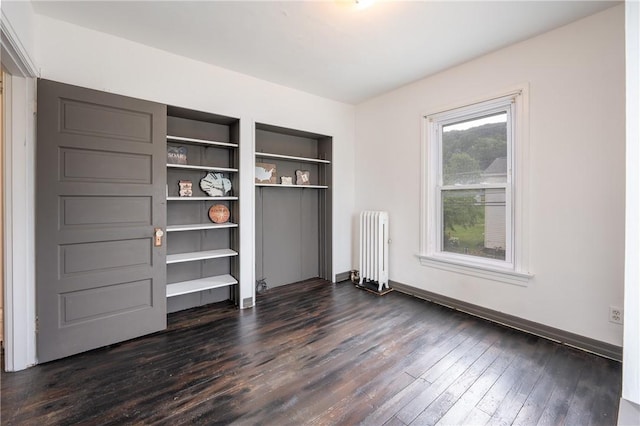 701 E 1st Ave, Derry Boro, PA 15627 - unfurnished bedroom with radiator heating unit and dark wood finished floors