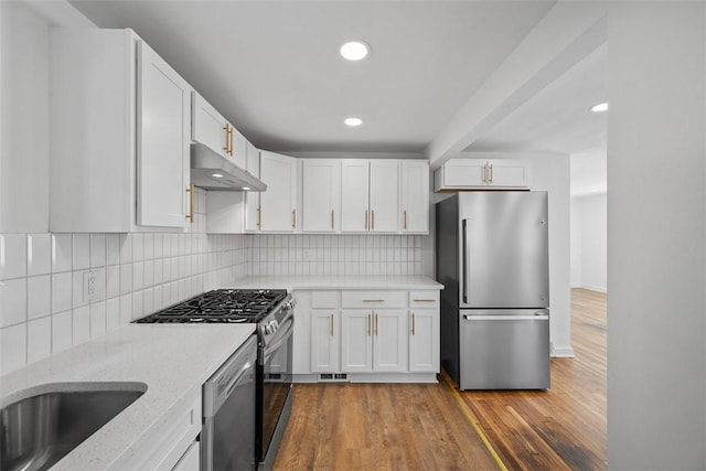 332 Garlow Dr, Penn Hills, PA 15235 - kitchen featuring stainless steel appliances, under cabinet range hood, white cabinetry, tasteful backsplash, and recessed lighting