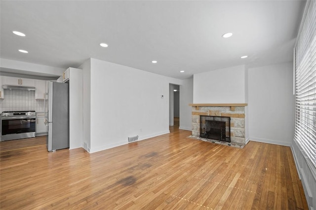 332 Garlow Dr, Penn Hills, PA 15235 - unfurnished living room with light wood-style floors, recessed lighting, and a stone fireplace