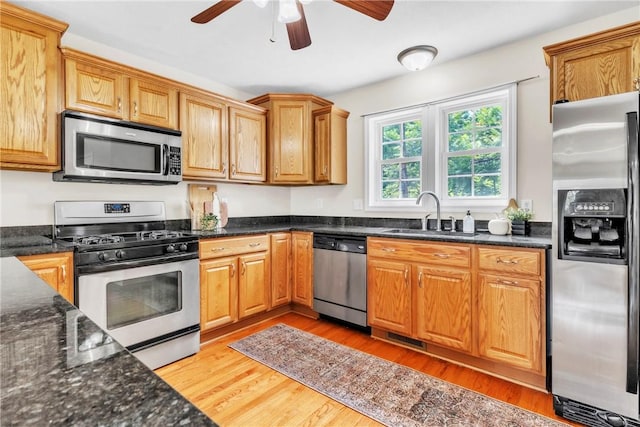 1109 Mary Ann, South Side, PA 15203 - kitchen featuring appliances with stainless steel finishes, ceiling fan, light wood-style flooring, and dark stone countertops