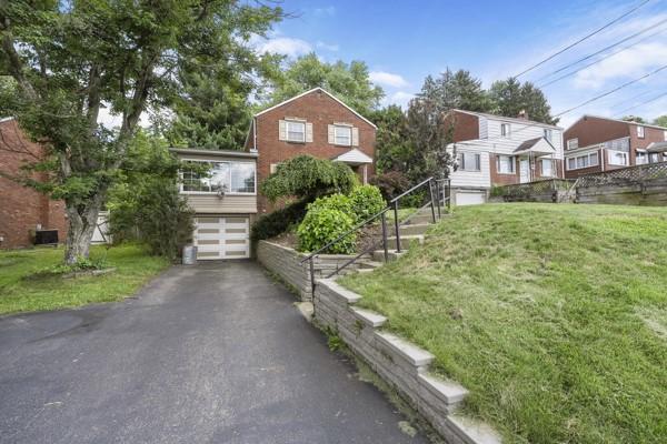 147 Rodilin Dr, Penn Hills, PA 15235 - view of front of house featuring a garage, a front lawn, and driveway