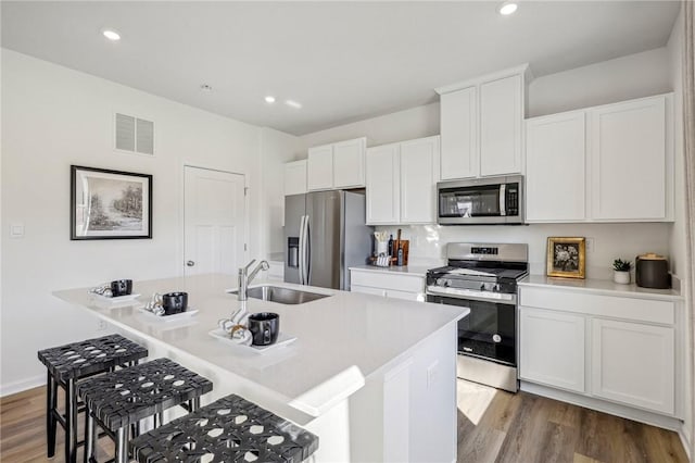 152 Smith Ln, Chippewa Twp, PA 15010 - kitchen with appliances with stainless steel finishes, a kitchen breakfast bar, wood finished floors, white cabinetry, and recessed lighting