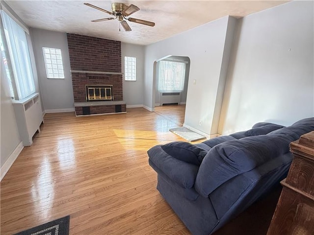 1606 Maryland Ave, West Mifflin, PA 15122 - living area featuring ceiling fan, radiator heating unit, light wood finished floors, and a fireplace