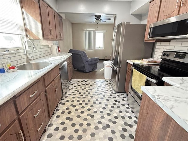 1606 Maryland Ave, West Mifflin, PA 15122 - kitchen with stainless steel appliances, a ceiling fan, light countertops, open floor plan, and tasteful backsplash