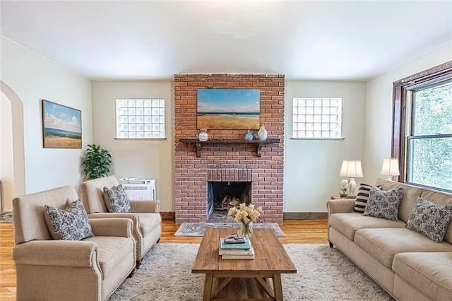 9502 Frankstown, Penn Hills, PA 15235 - living room featuring arched walkways, a brick fireplace, and wood finished floors