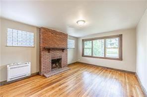 9502 Frankstown, Penn Hills, PA 15235 - unfurnished living room with wood finished floors, a fireplace, and a wall unit AC