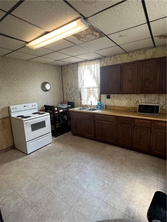 306 Fallowfield Ave, Charleroi Boro, PA 15022 - kitchen with electric range, a drop ceiling, light countertops, dark brown cabinetry, and light flooring