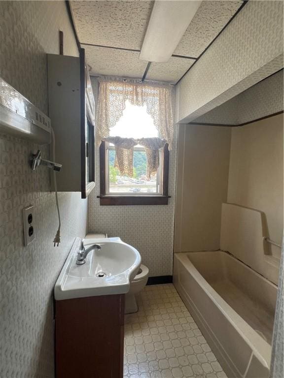 306 Fallowfield Ave, Charleroi Boro, PA 15022 - bathroom featuring wallpapered walls, vanity, tile patterned floors, and a tub to relax in