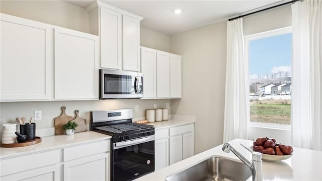164 Smith Ln, Chippewa Twp, PA 15010 - kitchen featuring appliances with stainless steel finishes, plenty of natural light, light countertops, white cabinets, and recessed lighting