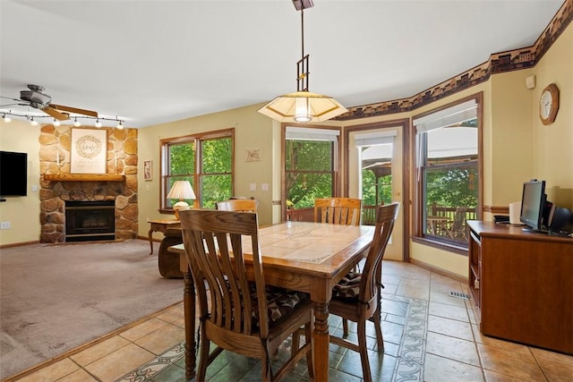4581 Bakerstown Culmerville Rd, West Deer, PA 15044 - dining space featuring a ceiling fan, a fireplace, light tile patterned flooring, and light carpet