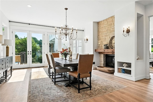 3901 Bakerstown Rd, Richland, PA 15044 - dining room featuring wood finished floors, french doors, a chandelier, a stone fireplace, and recessed lighting