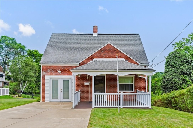 21 Garden Ter, Churchill Boro, PA 15221 - view of front of house with covered porch, roof with shingles, a front yard, and brick siding