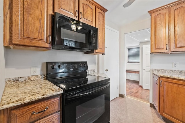 21 Garden Ter, Churchill Boro, PA 15221 - kitchen with black appliances, light stone countertops, and brown cabinetry