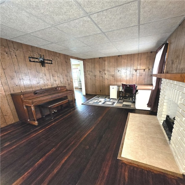 76 Foch Cir, Nemacolin, PA 15351 - unfurnished living room featuring wood walls, a fireplace, wood finished floors, and a paneled ceiling