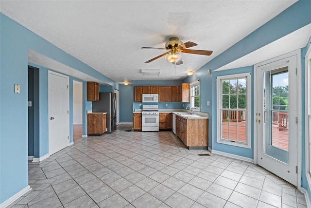 1445 Bristol Dr, South Park, PA 15129 - kitchen featuring white appliances, brown cabinetry, light countertops, a ceiling fan, and light tile patterned floors