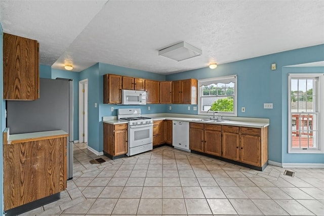1445 Bristol Dr, South Park, PA 15129 - kitchen featuring white appliances, brown cabinetry, light countertops, and a textured ceiling