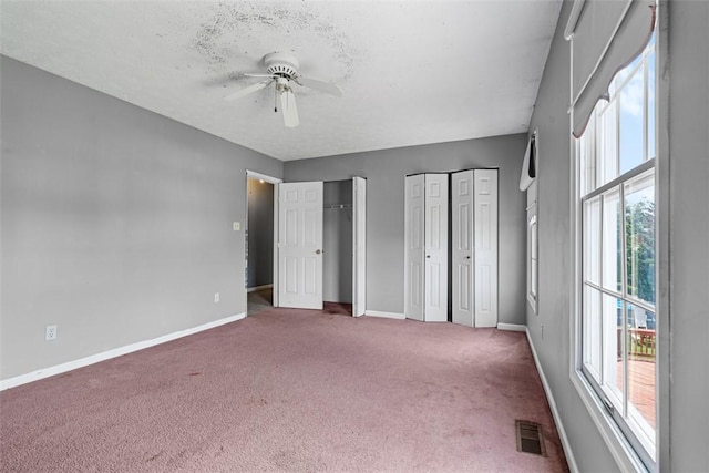 1445 Bristol Dr, South Park, PA 15129 - unfurnished bedroom featuring two closets, carpet floors, multiple windows, and a ceiling fan