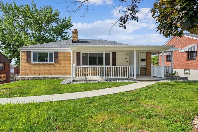 451 Charlotte Dr, Baldwin Boro, PA 15236 - view of front facade with covered porch, a front yard, a chimney, and brick siding