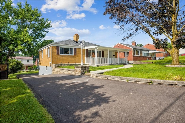 451 Charlotte Dr, Baldwin Boro, PA 15236 - ranch-style house with covered porch, brick siding, a front yard, and a chimney