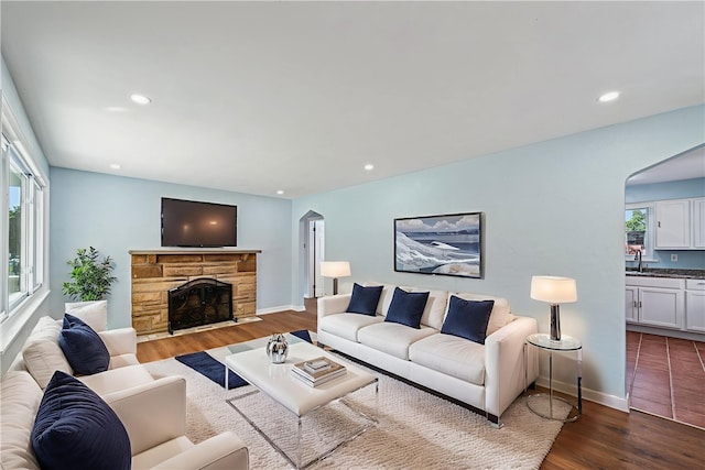451 Charlotte Dr, Baldwin Boro, PA 15236 - living area featuring arched walkways, dark wood finished floors, a fireplace, and recessed lighting