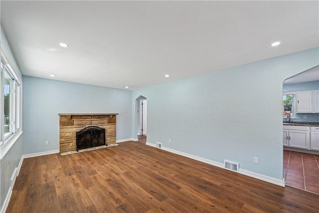 451 Charlotte Dr, Baldwin Boro, PA 15236 - unfurnished living room featuring arched walkways, a fireplace, dark wood-type flooring, and recessed lighting