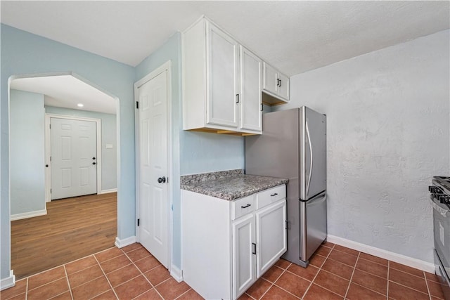 451 Charlotte Dr, Baldwin Boro, PA 15236 - kitchen with appliances with stainless steel finishes, white cabinetry, dark tile patterned flooring, and arched walkways