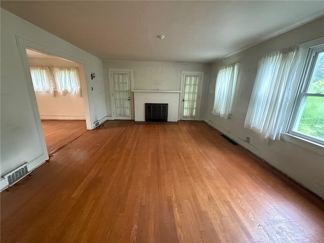 103 Belmont Rd, Twp Of But Ne, PA 16001 - unfurnished living room with wood finished floors, a brick fireplace, and plenty of natural light