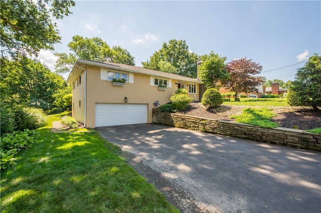 2633 Cedarvue Dr, Saint Clair, PA 15241 - view of front of home featuring an attached garage, asphalt driveway, a front yard, and stucco siding