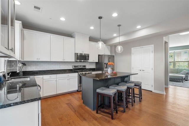 1004 Pointe View Dr, Adams Twp, PA 16046 - kitchen featuring appliances with stainless steel finishes, light wood-type flooring, white cabinetry, decorative backsplash, and recessed lighting