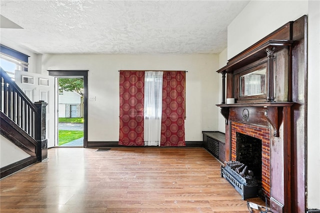 419 8th Ave, Patterson Heights, PA 15010 - entrance foyer with a textured ceiling, light wood-style flooring, stairs, and a fireplace