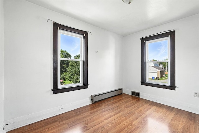 419 8th Ave, Patterson Heights, PA 15010 - empty room with baseboard heating, plenty of natural light, and wood finished floors