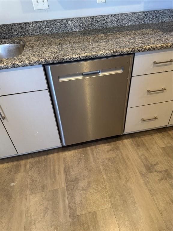 2411 Sarah St, South Side, PA 15203 - kitchen view of stainless steel dishwasher, wood finished floors, white cabinets, and dark stone counters