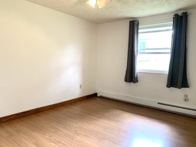 840 Lansberry Ct, Somerset Boro, PA 15501 - unfurnished room featuring a baseboard radiator, light wood-style floors, a textured ceiling, and ceiling fan