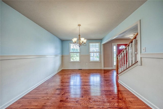102 Bridal Ln, North Fayette, PA 15071 - unfurnished dining area featuring wood finished floors, a chandelier, and stairway