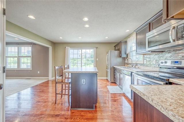 102 Bridal Ln, North Fayette, PA 15071 - kitchen with stainless steel appliances, a center island, recessed lighting, a textured ceiling, and light wood finished floors