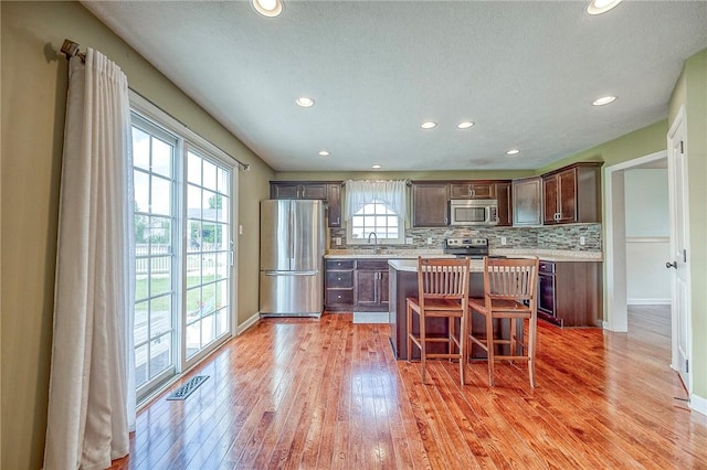 102 Bridal Ln, North Fayette, PA 15071 - kitchen with appliances with stainless steel finishes, light wood-style floors, a breakfast bar, light countertops, and recessed lighting