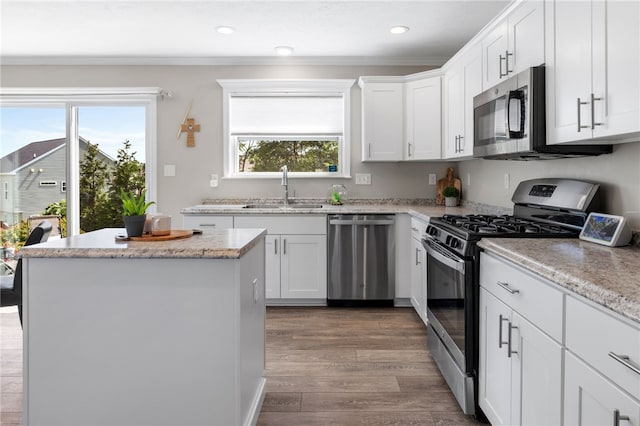 1026 Tee Line Dr, Hopewell Twp, PA 15001 - kitchen with appliances with stainless steel finishes, healthy amount of natural light, a kitchen island, white cabinetry, and crown molding