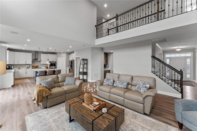 107 Valley View Dr, Brighton Twp, PA 15009 - living area featuring light wood-style flooring, a towering ceiling, stairway, and recessed lighting