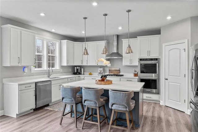 107 Valley View Dr, Brighton Twp, PA 15009 - kitchen featuring appliances with stainless steel finishes, wall chimney exhaust hood, a kitchen island, a breakfast bar, and white cabinetry