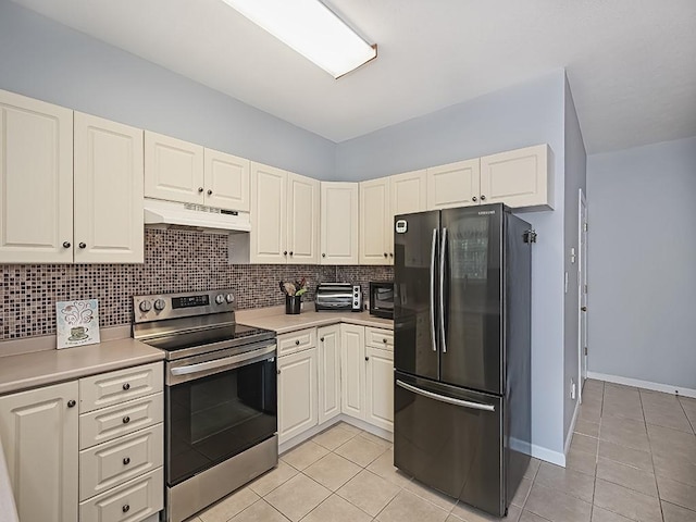 25 Elena Ave Unit 25, Lower Burrell, PA 15068 - kitchen with electric range, freestanding refrigerator, under cabinet range hood, light tile patterned flooring, and backsplash