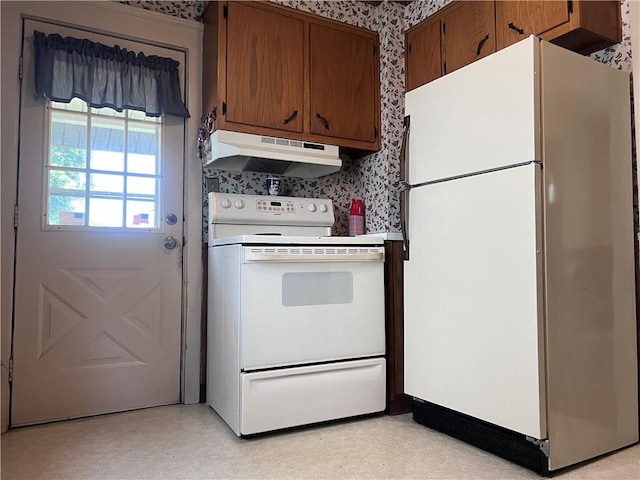 1613 E Washington St, New Castle, PA 16101 - kitchen with white appliances, under cabinet range hood, wallpapered walls, brown cabinets, and light countertops