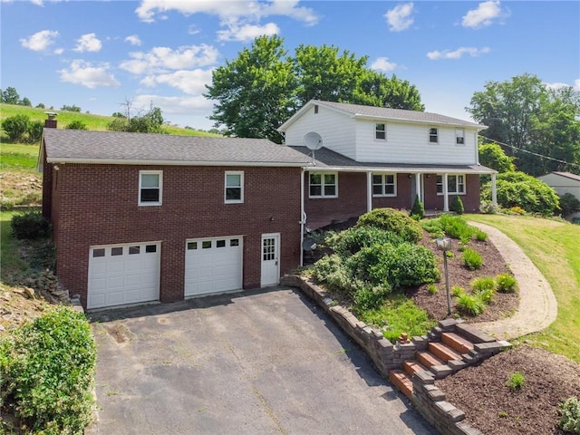 359 Meadow Spring Rd, Unity Twp, PA 15650 - traditional-style house featuring a garage, driveway, brick siding, and a chimney