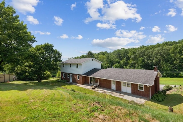 359 Meadow Spring Rd, Unity Twp, PA 15650 - back of house featuring brick siding, a chimney, a patio area, a lawn, and french doors