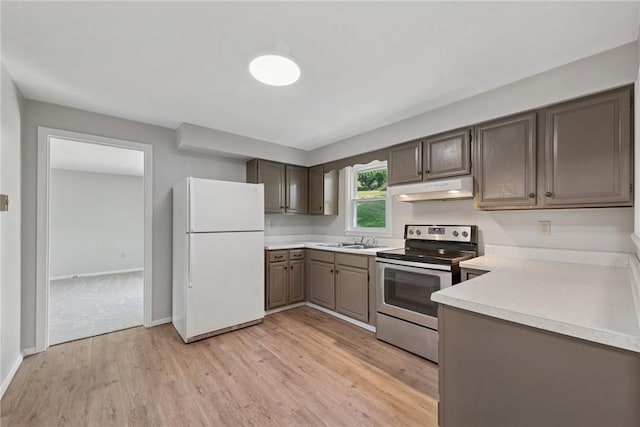 359 Meadow Spring Rd, Unity Twp, PA 15650 - kitchen with freestanding refrigerator, electric stove, under cabinet range hood, light wood-style flooring, and light countertops